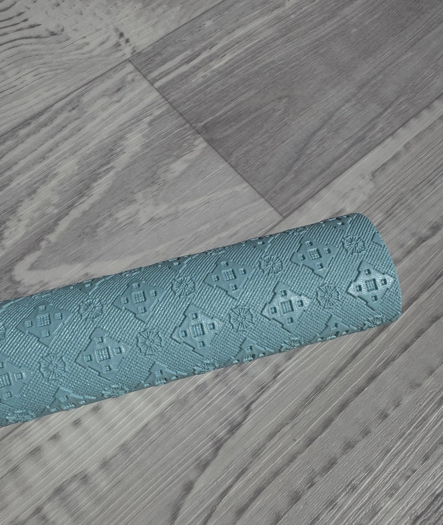 embossed vinyl in light blue, on a textured wood floor